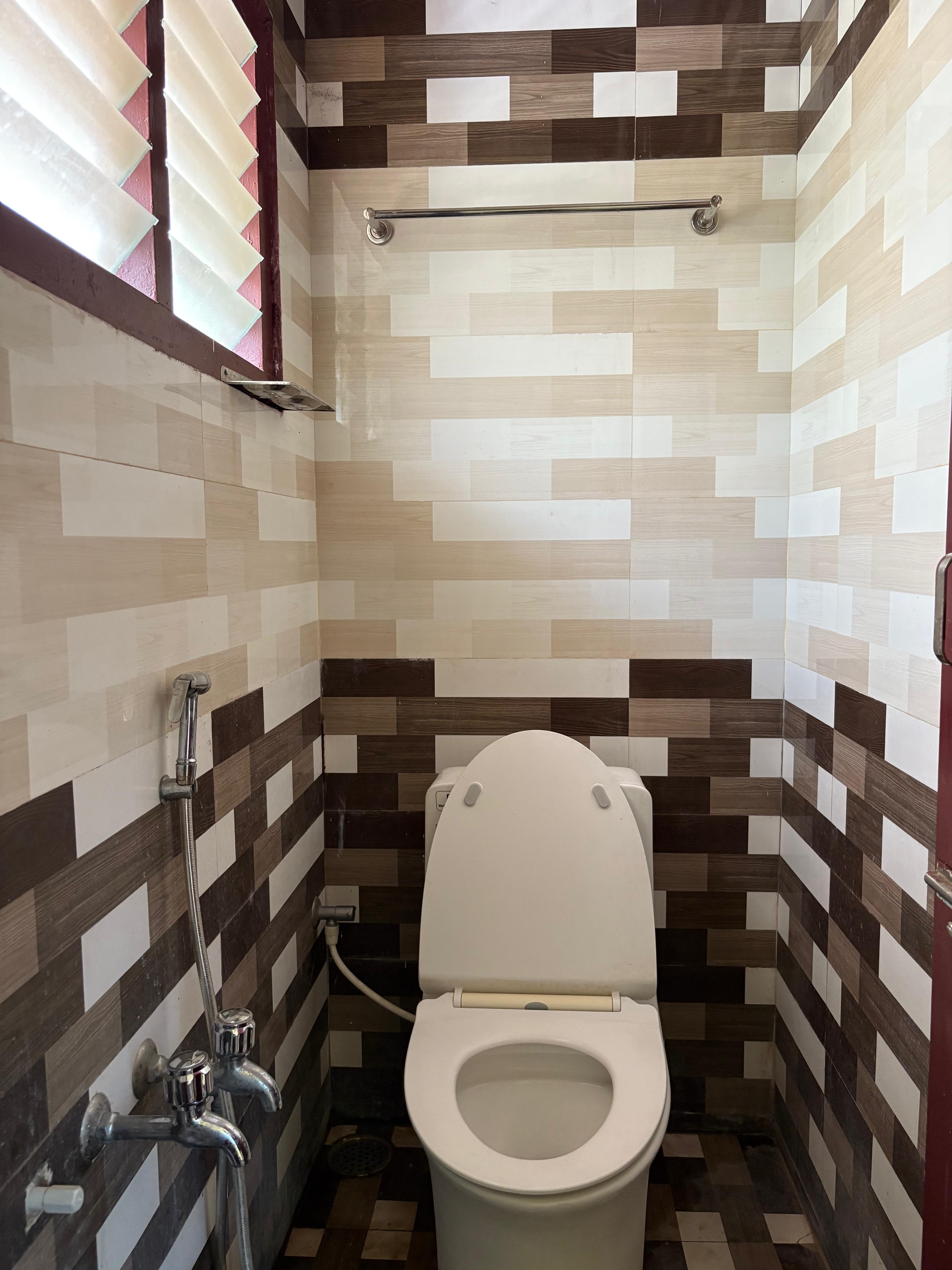 Clean tiled toilet with health faucet